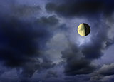 Moon glowing in the dark cloudy night sky