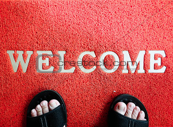 Closeup red mat with welcome and foot