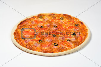 Pizza with tomatoes, ham, cheese and olives on a white sauce on a white background