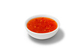 Chilli sauce in a gravy boat on white background