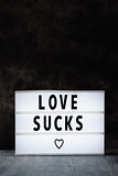 text love sucks in a lightbox