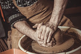 Adult male potter master mashing the clay