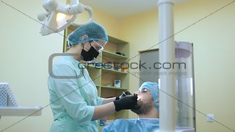 Doctor and patient in the dental office, inspection and examination the mouth