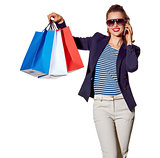 woman talking on a smartphone and showing shopping bags