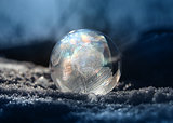 Frozen soap bubble ball on winter snow