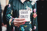 woman shows notepad with the text gender equality