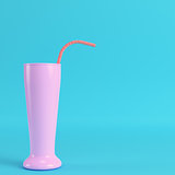 Cocktail glass with straw on bright blue background