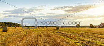 Scenic view of hay stacks on sunny day