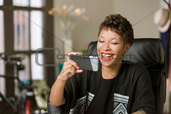 Laughing Woman with a Phone in Her Office