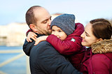 portrait of family of three having fun together by the ocean shore and enjoying the view. Outdoors