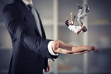 Businessman is saved from a big hand. Concept of business support and assistance
