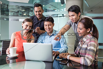 Multi-ethnic team of employees watching a funny video or presentation