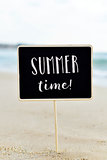 text summer time in a signboard on the beach