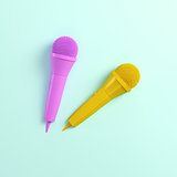 Pink and yellow microphones on bright background