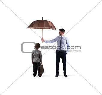 Businessman with umbrella that protect a child. Concept of young economy and startup protection