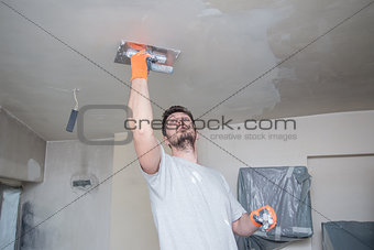 Worker Plastering Ceiling