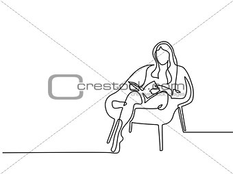 Woman sitting with book in chair