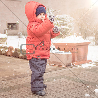Boy smiles cheerfully while snows