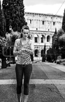 young woman jogger in Rome, Italy using fitness bracelet