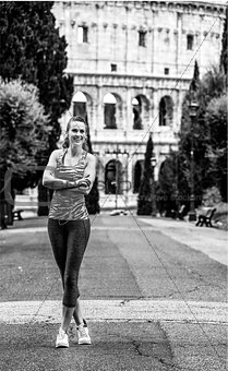 smiling young sportswoman standing in Rome, Italy