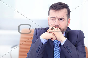 Tired business man at workplace in office holding his head on hands. Sleepy worker early in the morning after late night work. Overworking, making mistake, stress, termination or depression concept