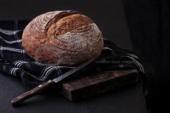 Freshly baked  bread with  kitchen towel and knife