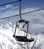Chair lift in snowy mountains at nice sun day