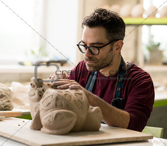Ceramist Dressed in an Apron Sculpting Statue from Raw Clay in Bright Ceramic Workshop.