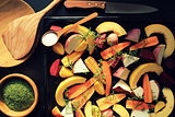 Top view of pan full of fall seasonal vegetables ready to be grilled over a dark background
