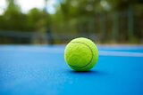Yellow ball on blue tennis court background.