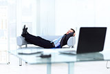 Portrait of happy businessman relaxing in office