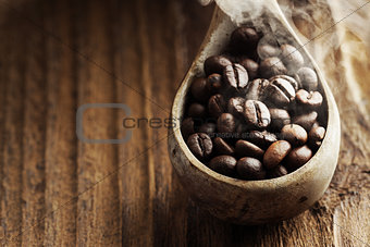 Close up of wooden spoon with coffee beans on it