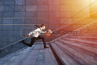 Businessman runs fast over a modern staircase