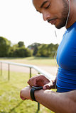 Male athlete at running track setting smartwatch app