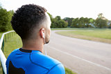 Male athlete at track looking away, close up, back view