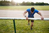 Male athlete stretching at running track, close up