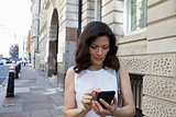 Woman in the street navigating with smartphone, waist up