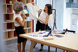 Two women discussing clothes in a creative media office
