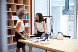 Two women talking in a creative media office