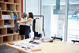 Two women discussing clothes in a creative media office