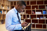 Young black man using smartphone in a boardroom, close up