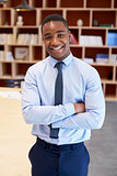 Young black man smiling to camera in a boardroom, vertical