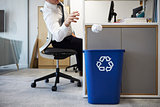 Man at desk throwing screwed up paper into recycling bin