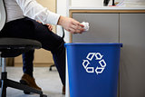 Man dropping screwed up paper into recycling bin, close up