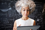 Middle aged academic woman using tablet, close up