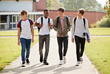 Group Of Male Teenage Students Walking Around College Campus