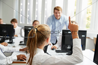 Teenage Students Asking Teacher Question In IT Class