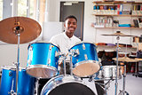 Male Teenage Pupil Playing Drums In Music Lesson