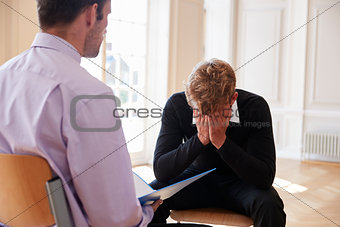 School Counselor Talking To Depressed Male Pupil