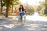 Girl Riding Bike Along Street To School